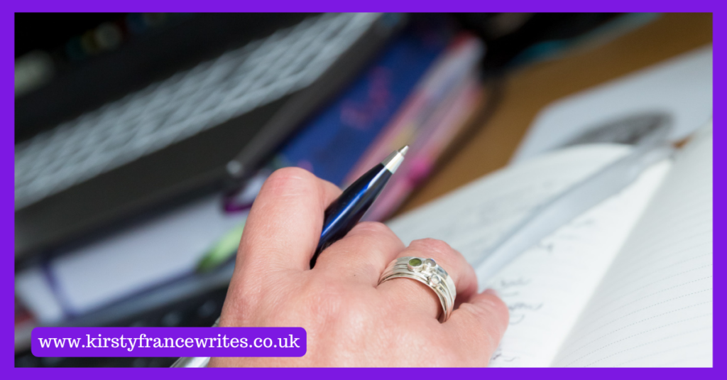 The image shows my hand holding a pen while I think about writing a good blog post.